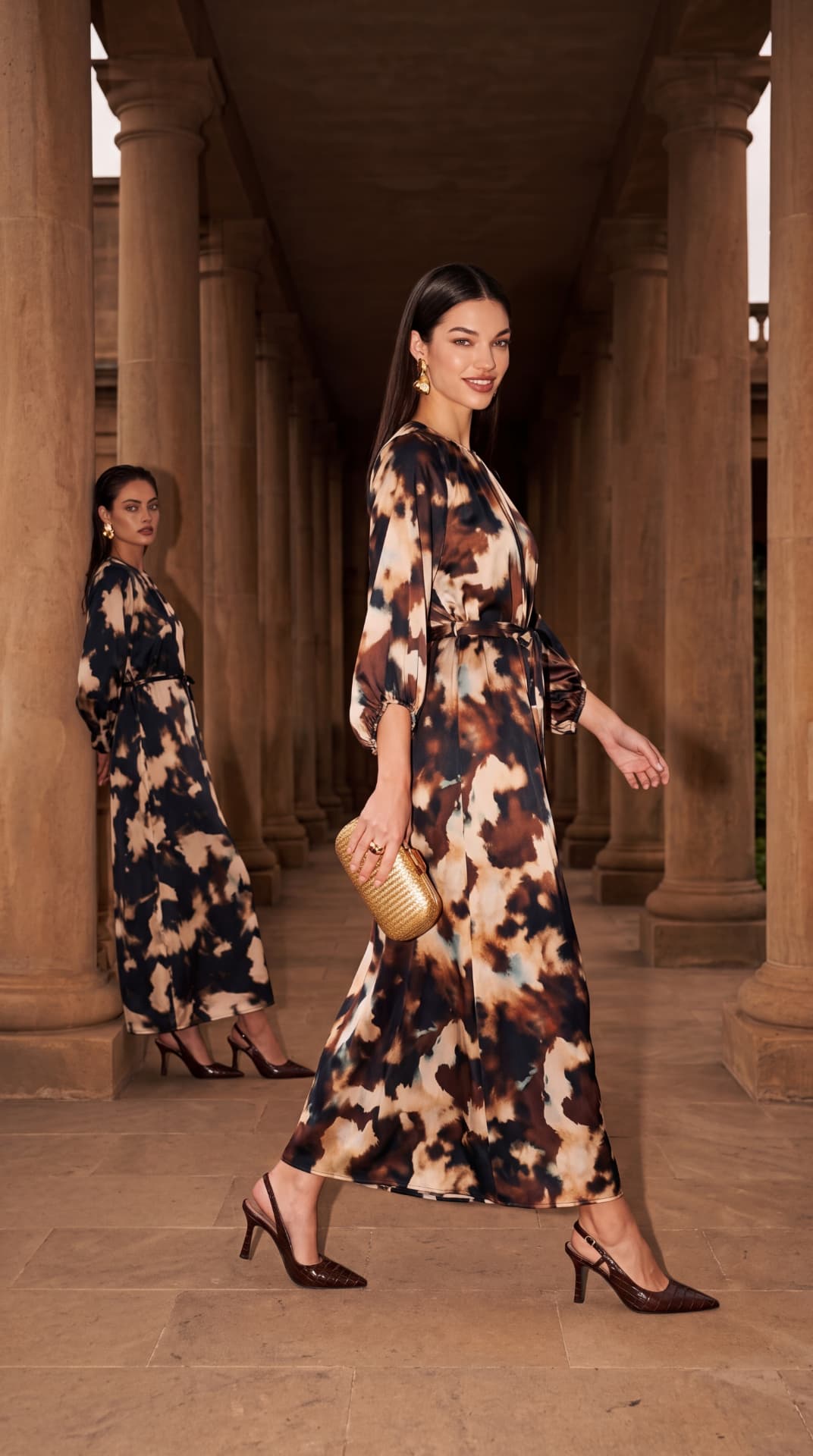 שתי דוגמניות בשמלות מקסי מודפסות במסדרון עמודים — קמפיין AI דואו